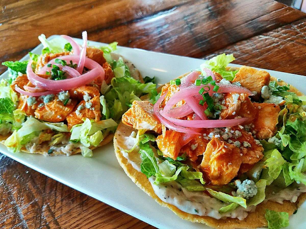 two large fish tacos with vegetables and sauce