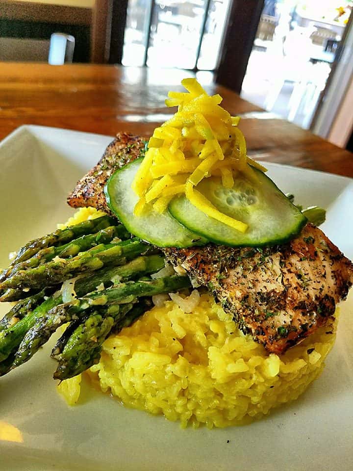 cooked fish over rice with asparagus and cucumbers
