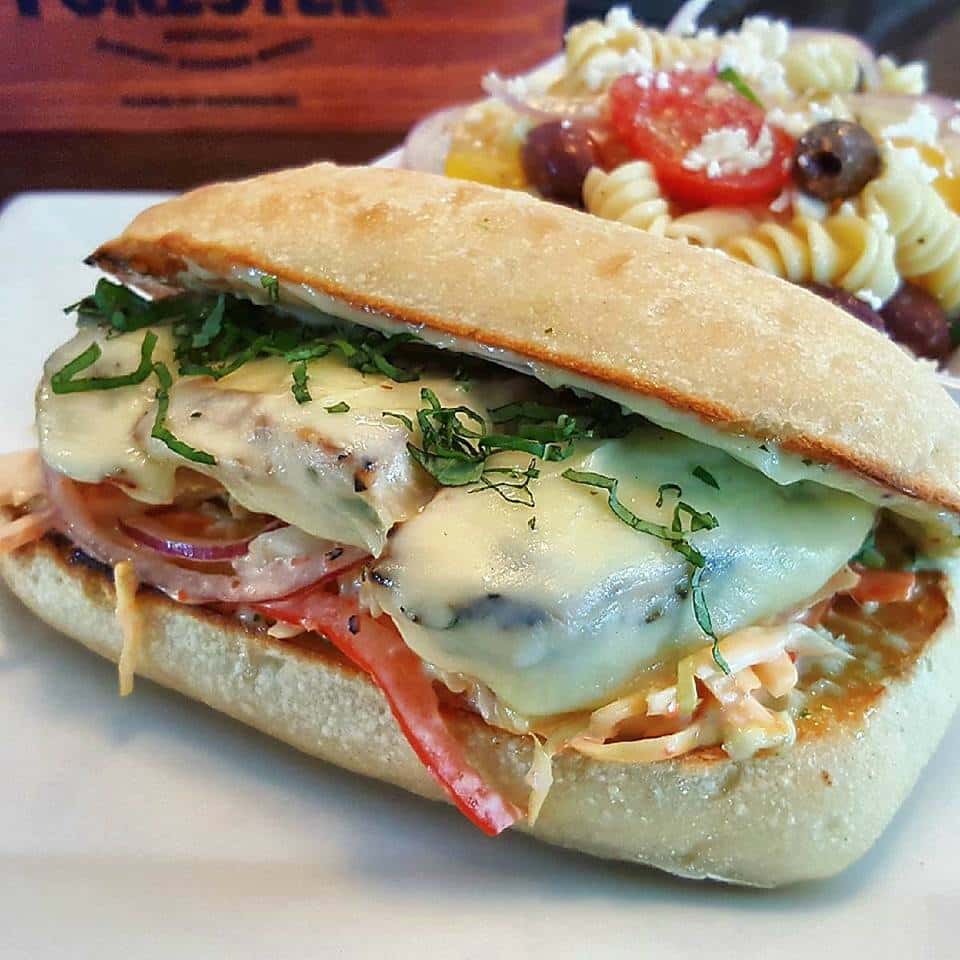 chicken sun with cheese, lettuce and onions with a side of pasta