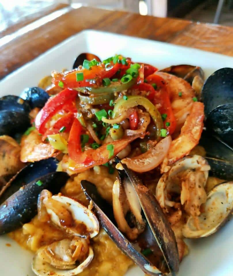 bowl of cooked shrimp, mussels and clams covered in sauce