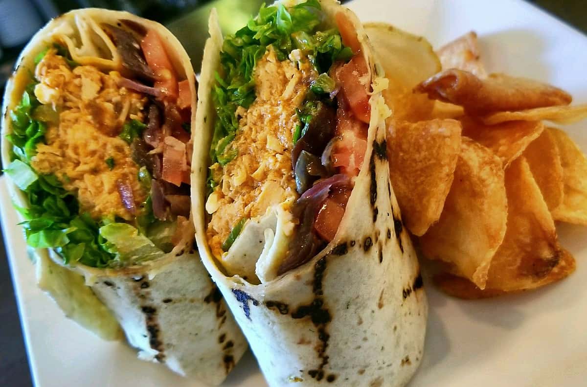 chicken wrap with beans, lettuce and tomatoes with a side of fries