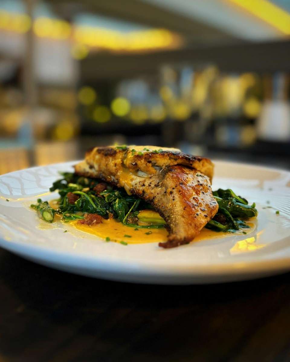 Crab Crusted Redfish with sautéed arugula, bacon, asparagus, and bourbon-sweet corn sauce