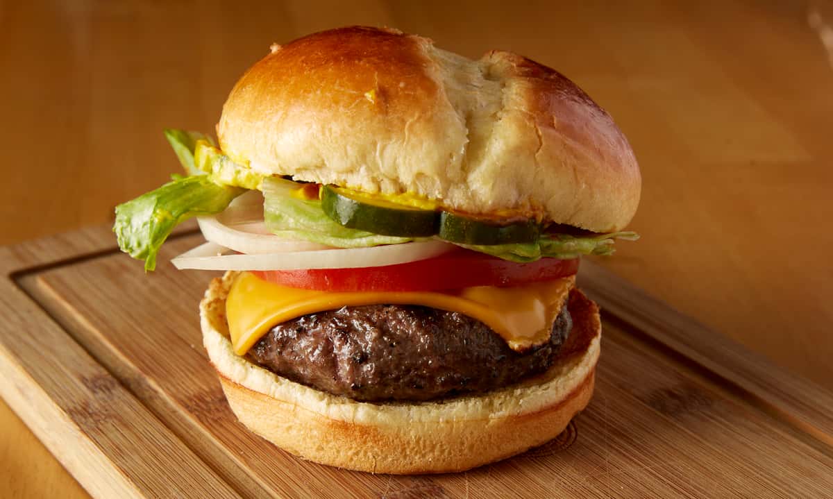 Burger with cheese, lettuce, onions and tomato