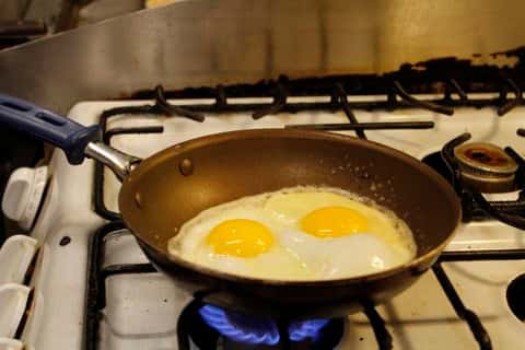 two eggs cooking on a pan