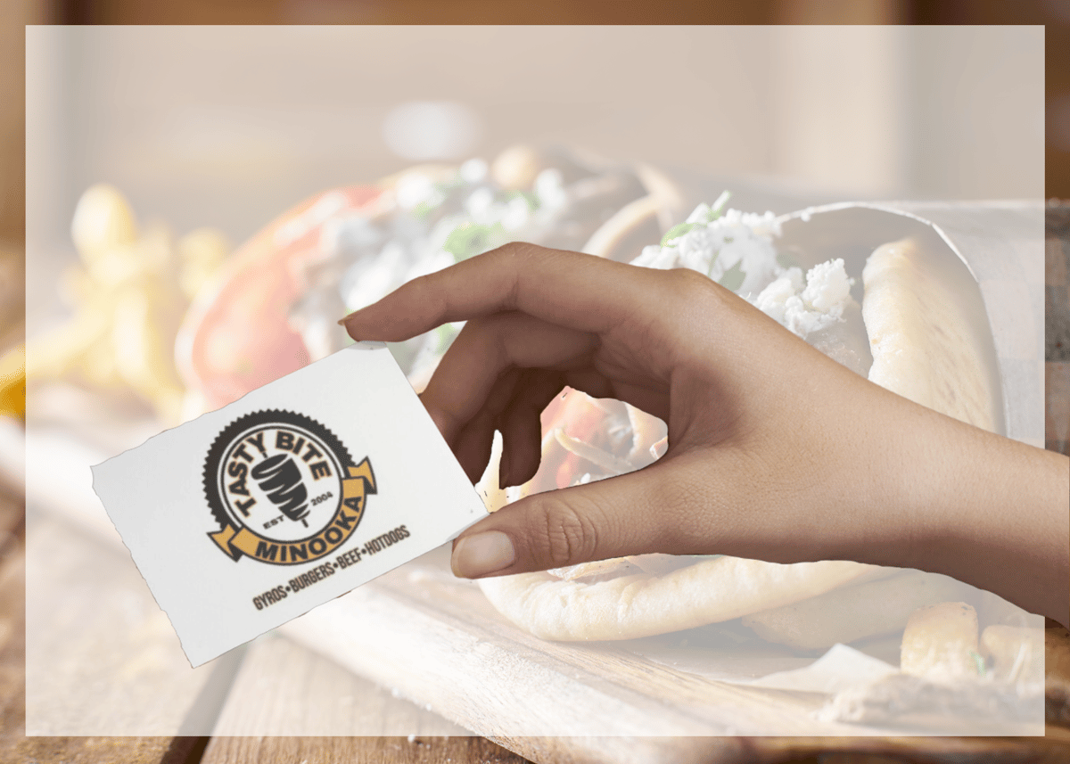 Hand holding gift card in front of opaque food image