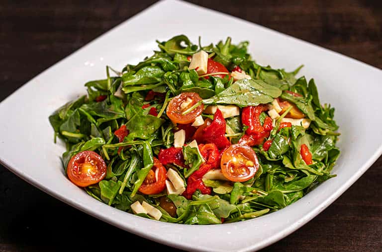 Fresh arugula salad with tomatoes, greens and shaved cheese at Avenue Bistro