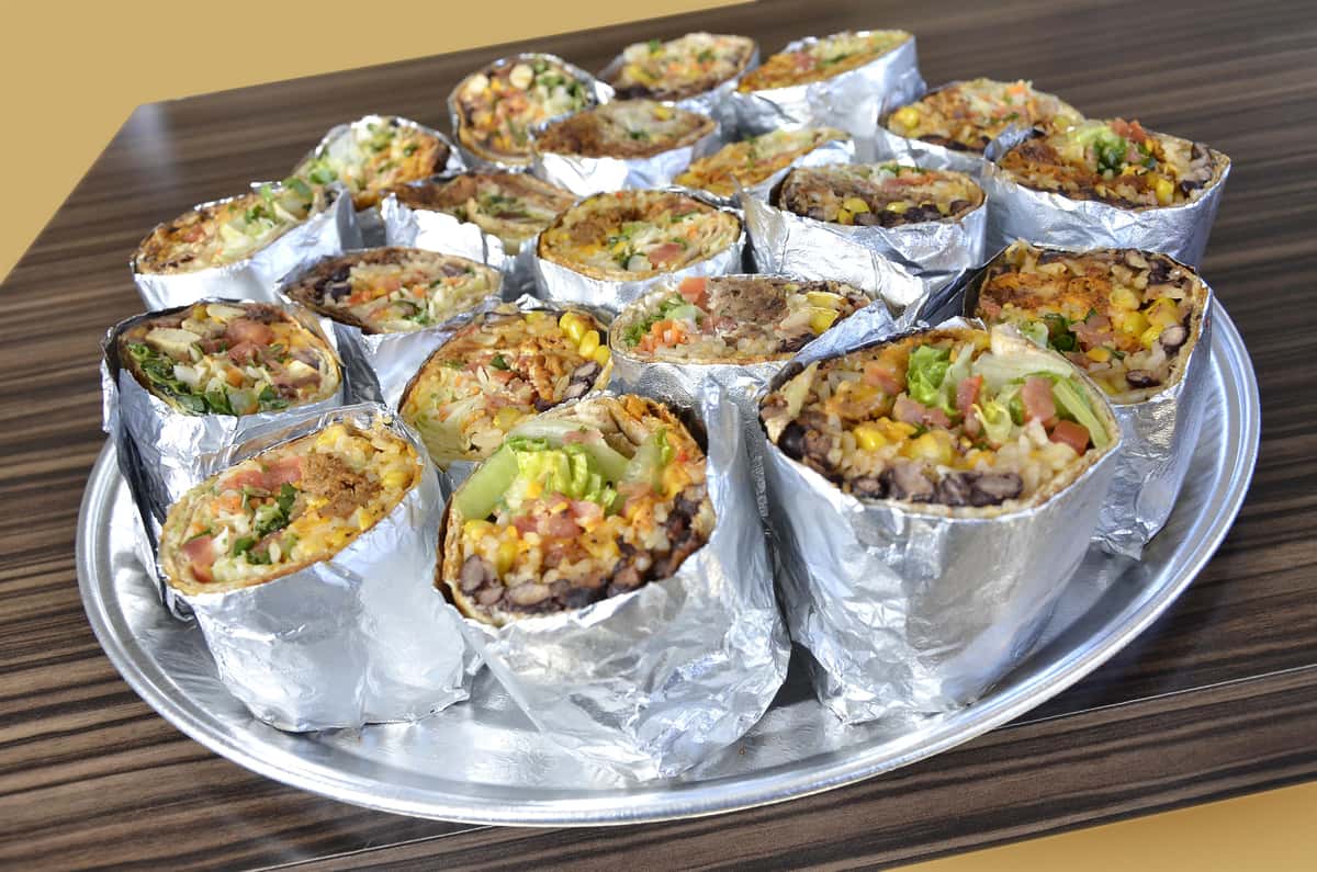 Burrito halves in foil on tray