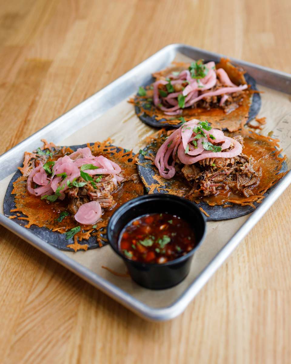 Blue Maize tortillas Oaxaca cheese, Prime short rib, onions, cilantro
