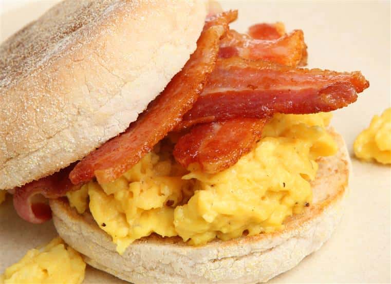 a english muffin with eggs and bacon on it