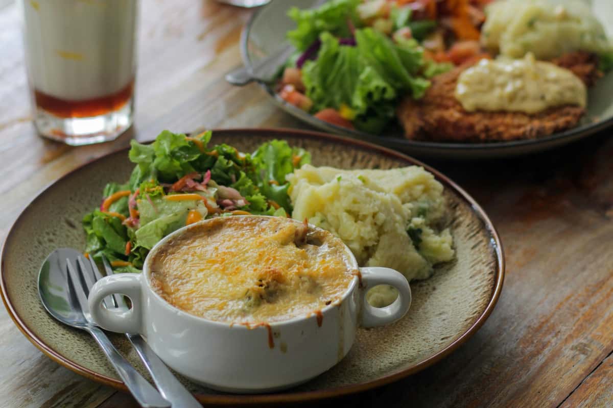 Plate with rice, salad, and saucy main meal