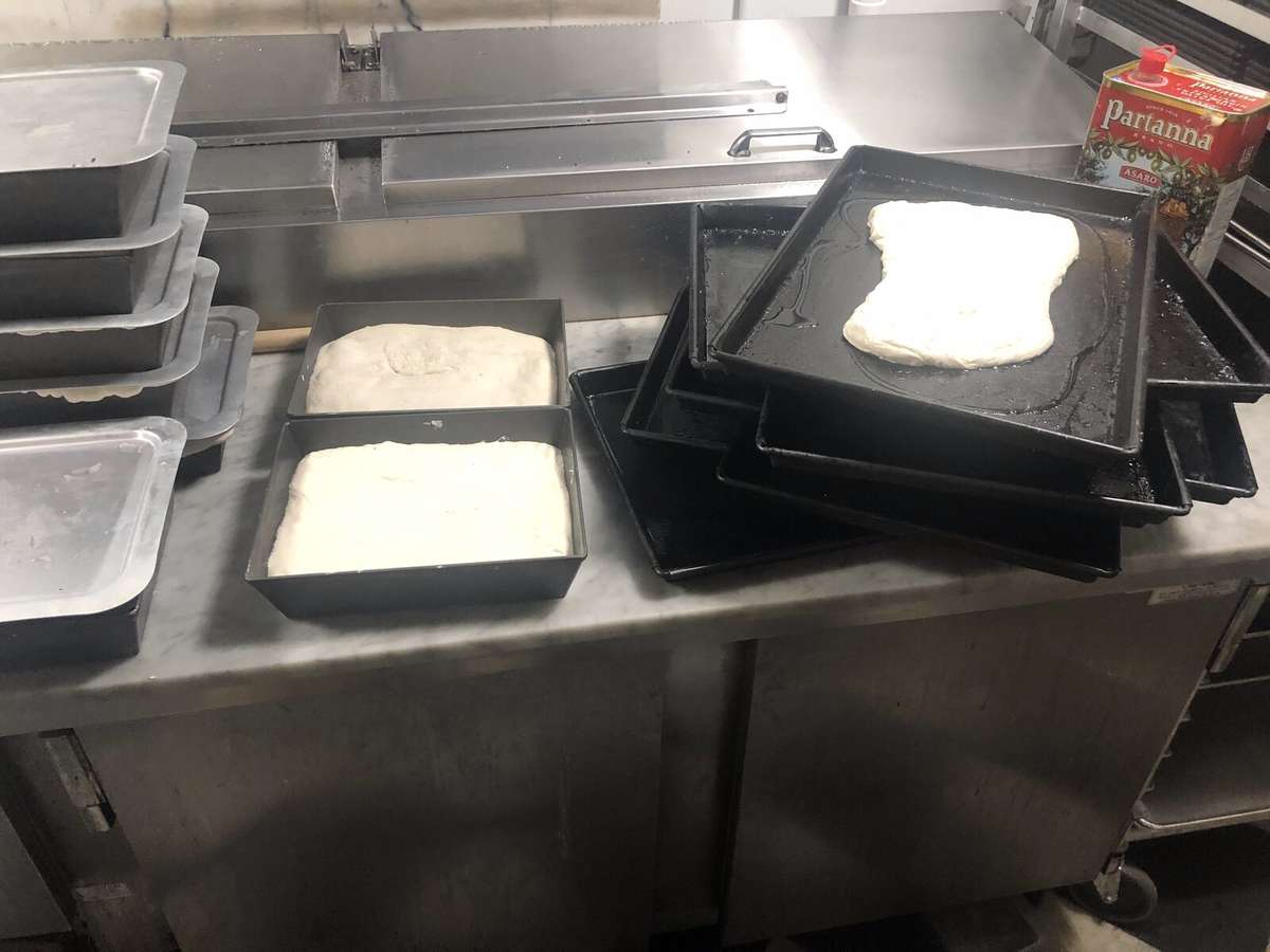 Roman pan pizza dough resting in tubs on the bench at Teglia Pizza Bar in Montclair NJ