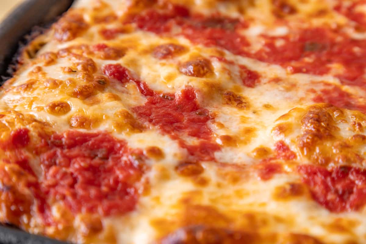 Close-up of classic Jersey-style cheese pizza with bubbling mozzarella and tomato sauce