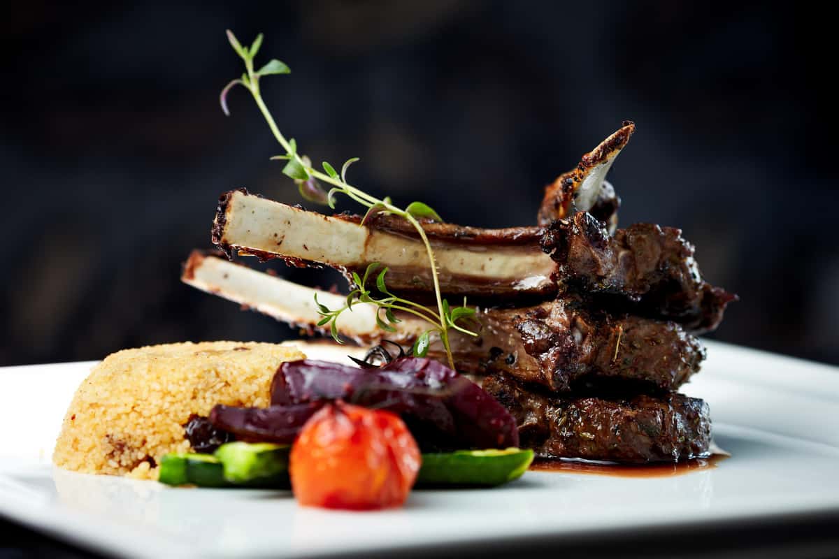 Lamb chops with assorted vegetables and couscous on plate