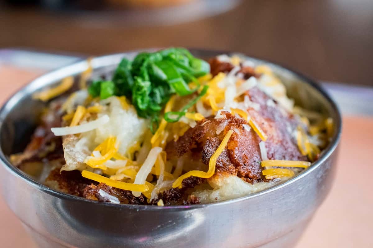 Smashed potatoes, cheese, chives and bacon. grilled on the flattop.