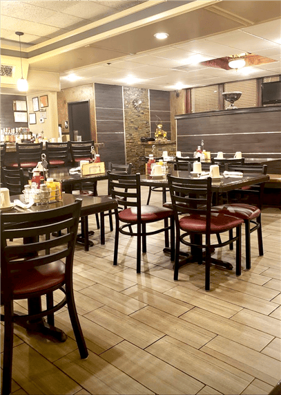 A view of the dining room with set tables and chairs