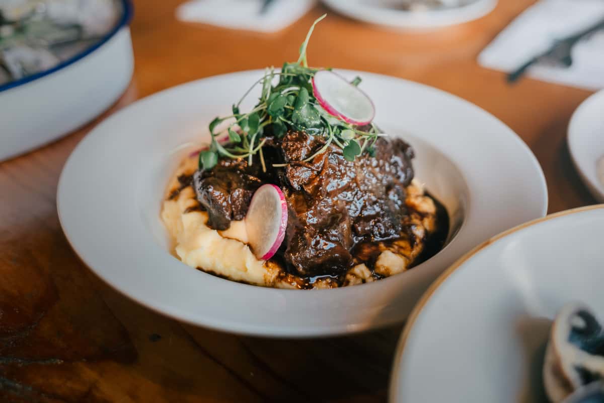 Close-up of gourmet beef served with mashed potatoes on a stylish plate.