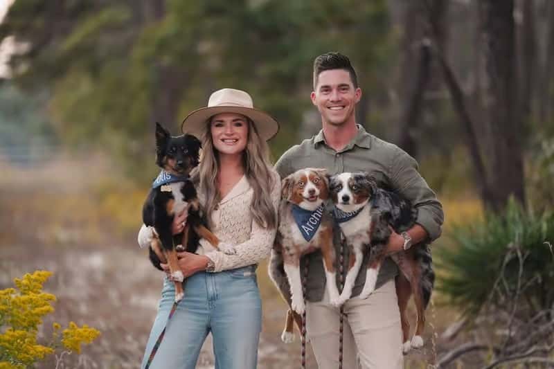 Restaurant owners posing outdoors with their dogs, highlighting the welcoming, family-friendly personality behind the business.