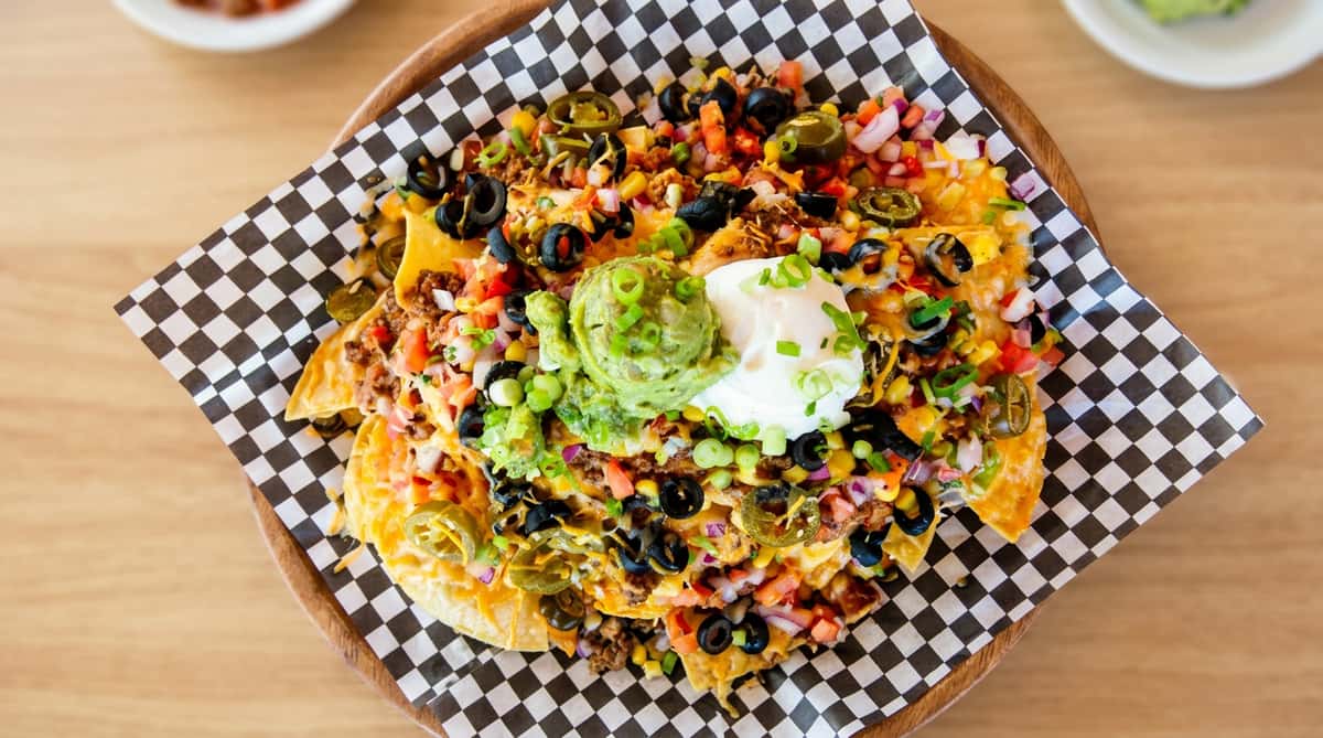 Loaded nachos on a checkered takeout paper
