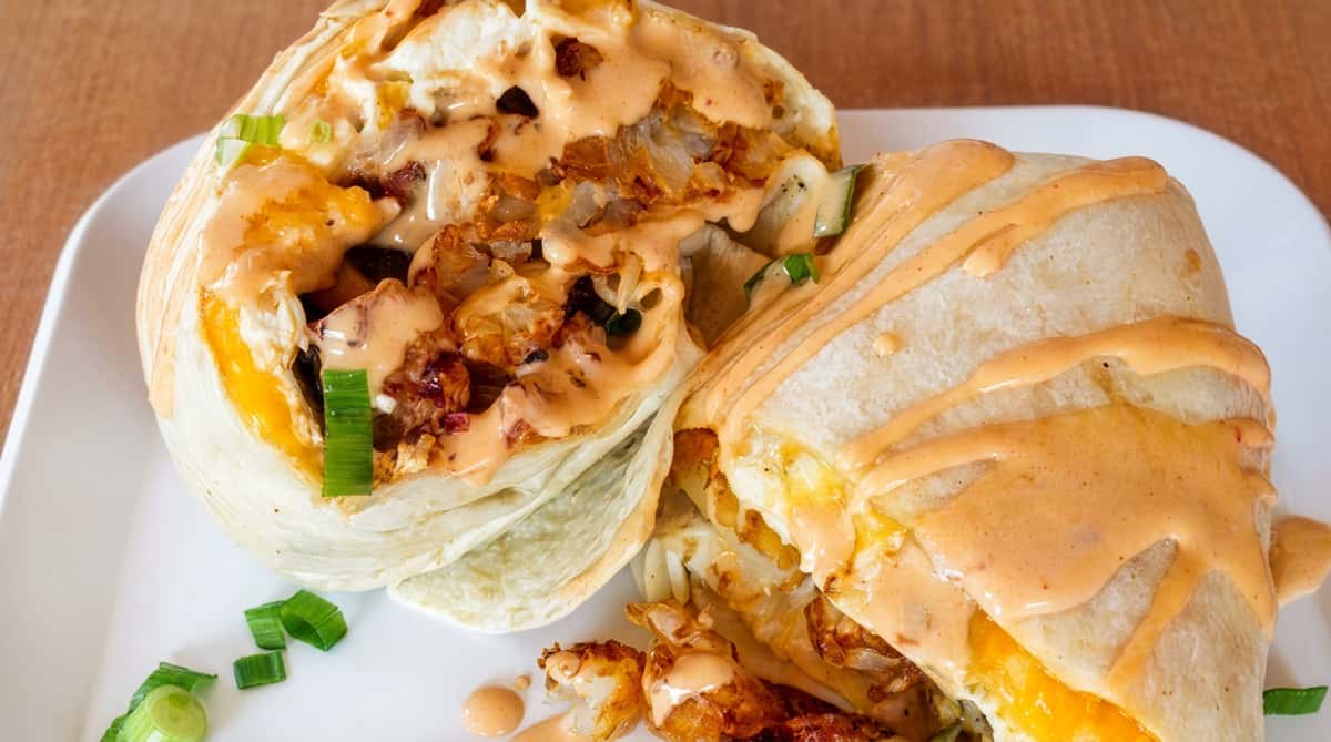 Close up of burrito drizzled with sauce