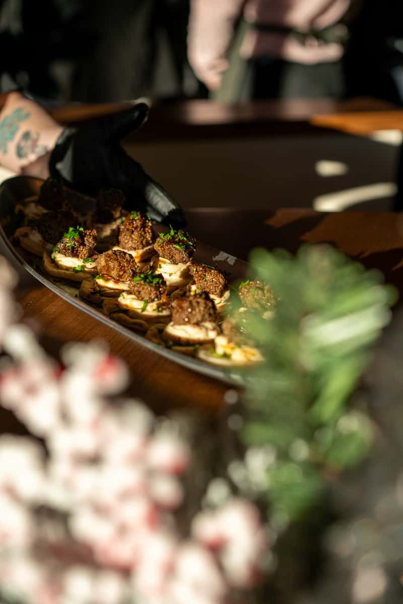 A rectangular platter showcases an assortment of elegantly presented hors d'oeuvres