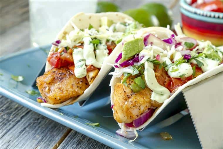 two fish tacos with salsa, red onion and coleslaw
