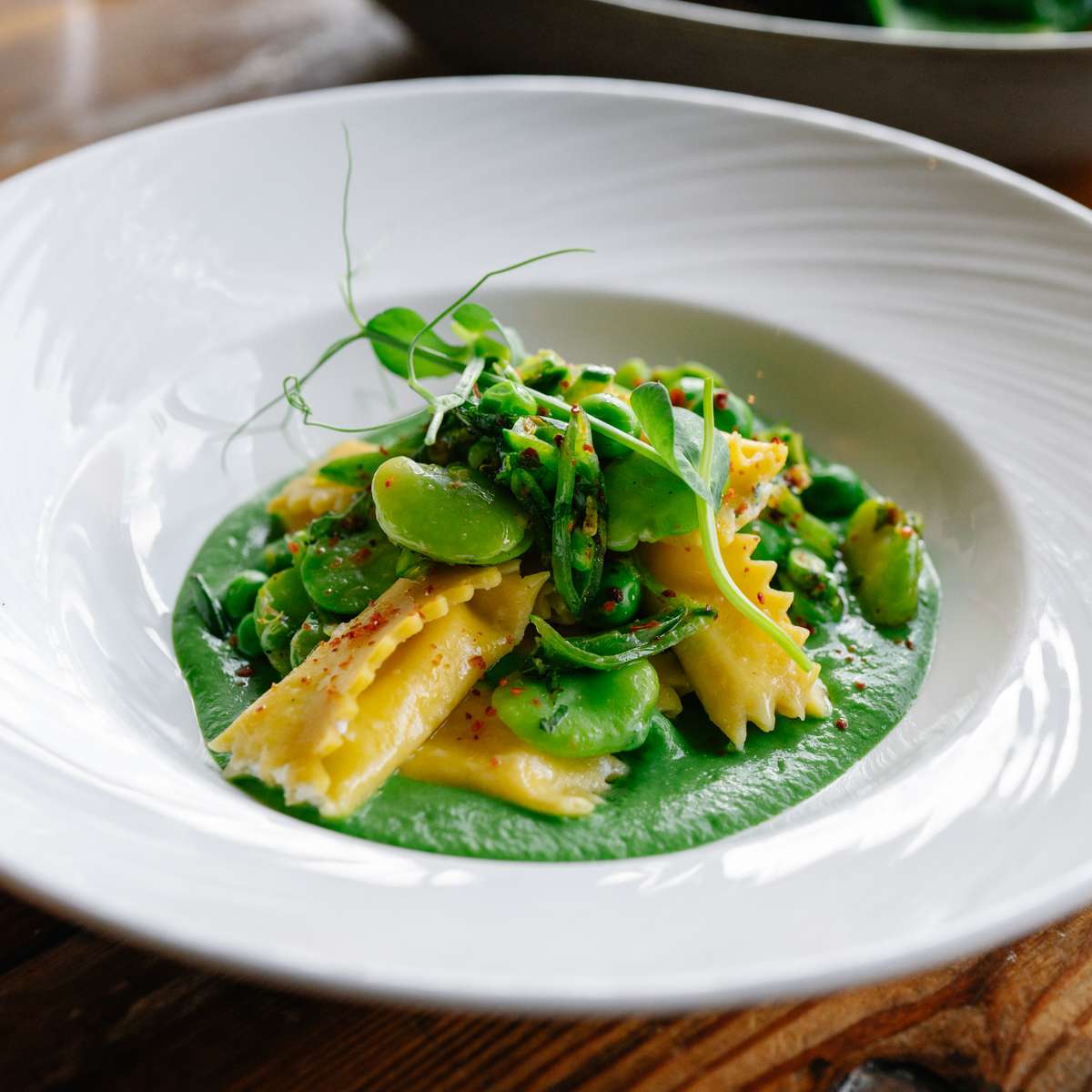 White plate with past and green sauce