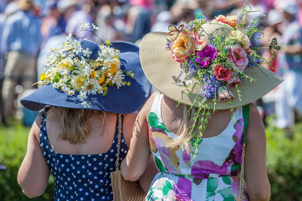 2 ladies wearing traditional horse race hats