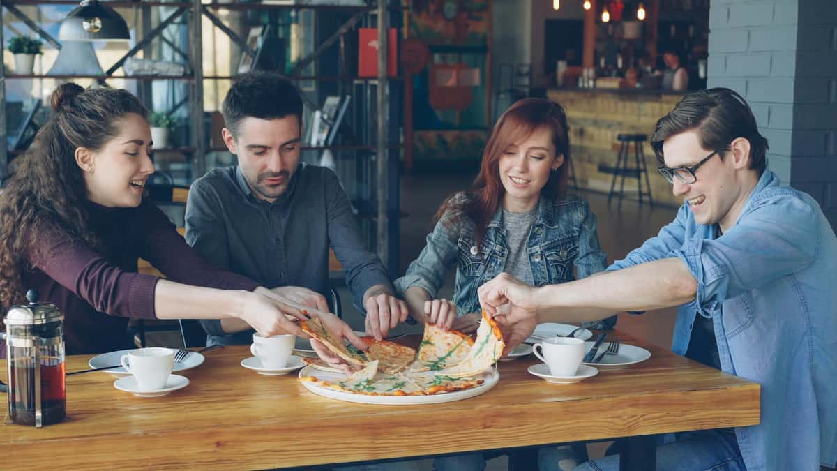 Friends Enjoying Pizza in a Cozy Café