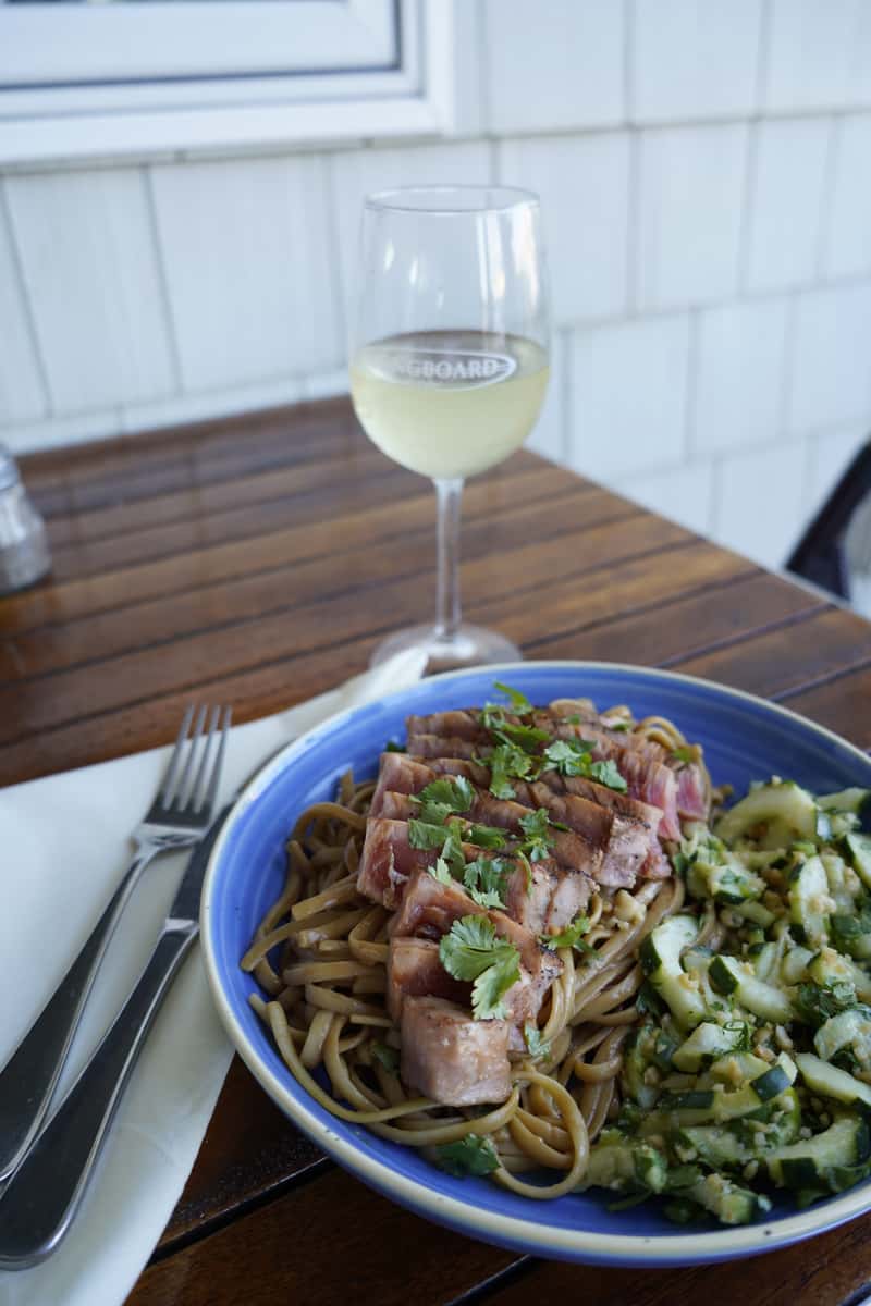 Perfectly grilled steak served over a bed of crispy golden fries, topped with fresh herbs for added flavor. Paired with a refreshing glass of white wine and a side of creamy coleslaw, this hearty entrée delivers the perfect balance of comfort and coastal dining.