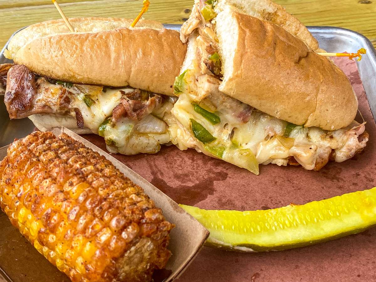 Meaty sandwich and corn on the cob