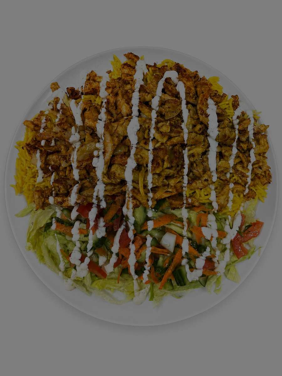 Mediterranean chicken shawarma platter with seasoned yellow rice, fresh salad, and creamy garlic sauce drizzled over grilled chicken.