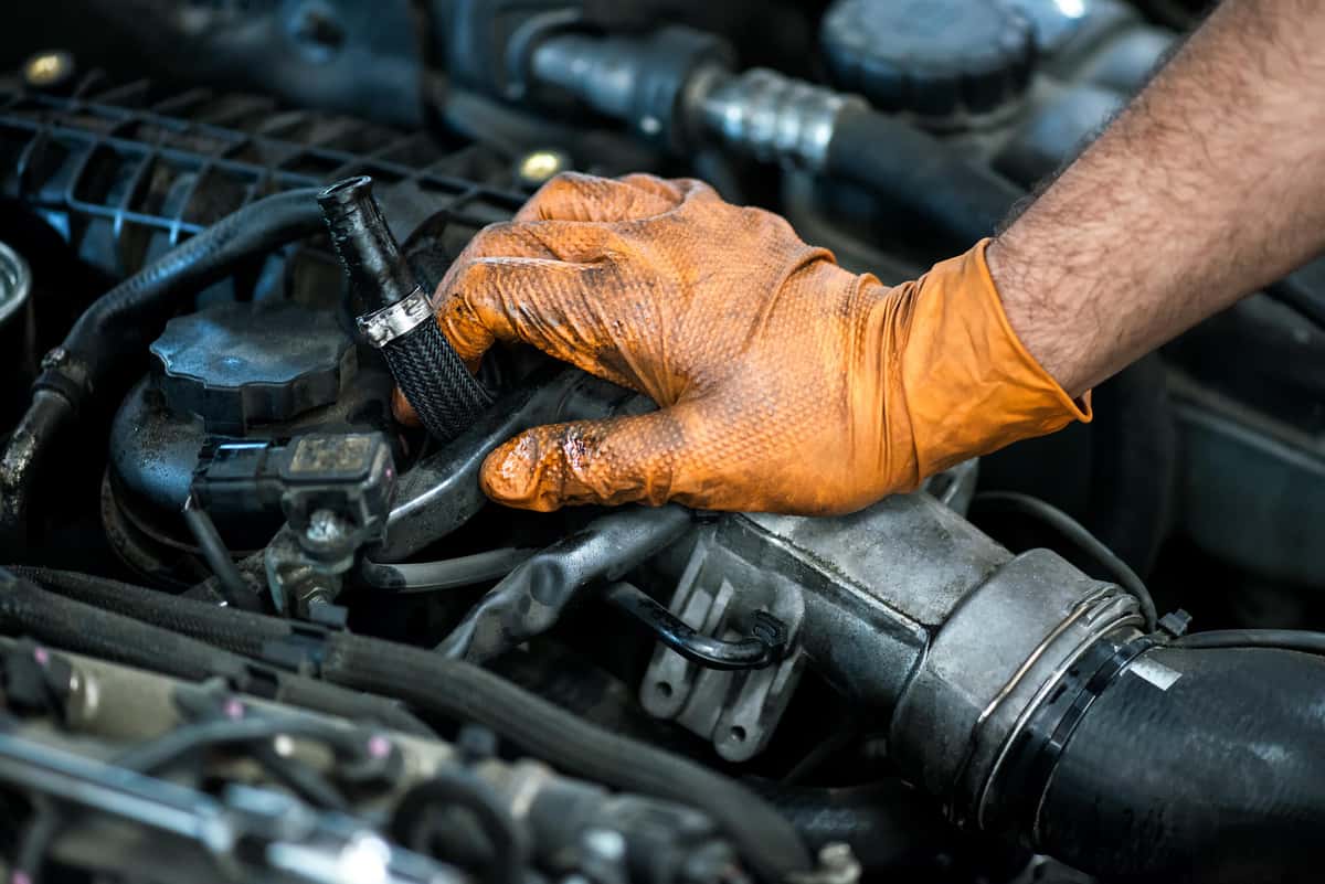 technician wearing a glove working on an engine