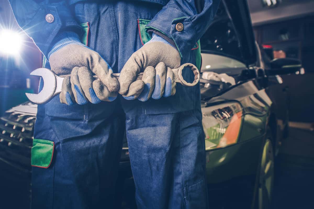 technician wearing gloves holding a wrench