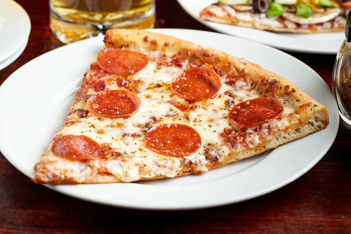 pepperoni pizza slice on a white plate