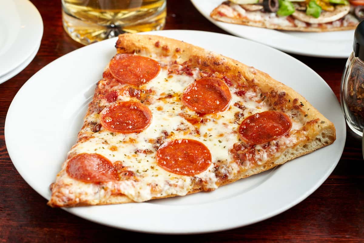 Slice of pepperoni pizza reheated