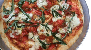 Neopolitan pizza topped with lite tomato sauce, Italian cherry tomatoes, fresh mozzarella, fresh basil, Tuscan EVOO, spices