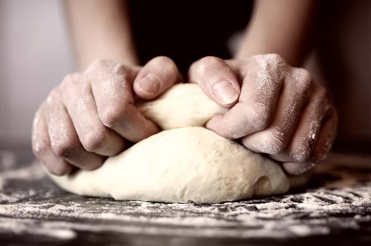 Chef kneading pizza dough
