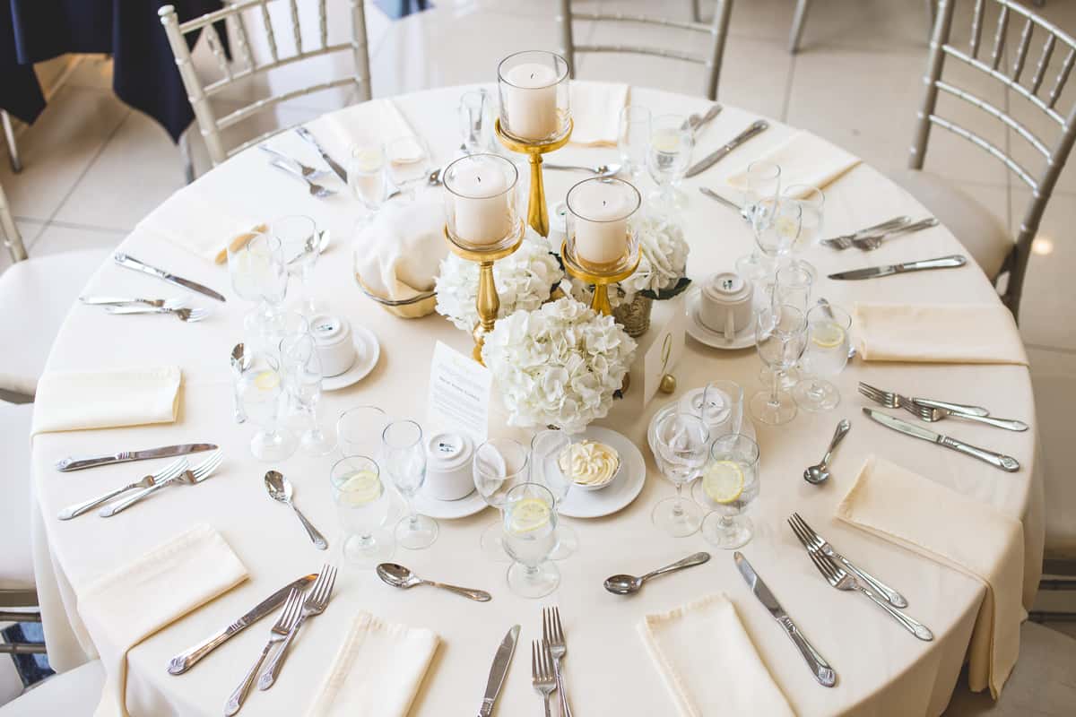 aerial view of a table setting with plates, forks, knives, glasses, and napkins
