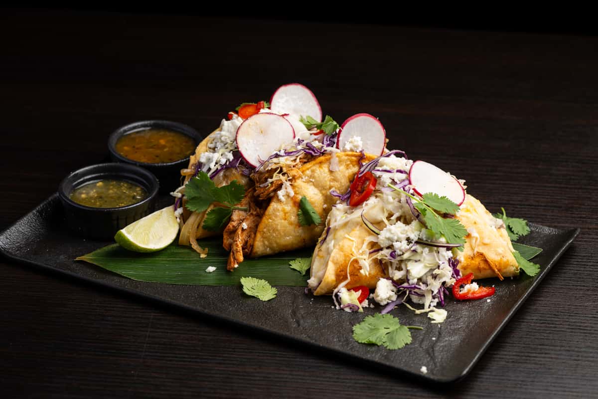 Three hard shell tacos, choice of braised pork, chicken mole, potato and cheese, served with cabbage, salsa fresca, guacamole, queso fresco
