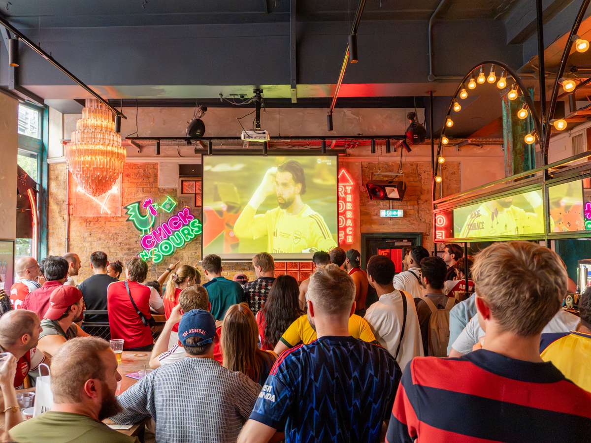 photo showing a football match being played at the big chill bar on a large tv screen