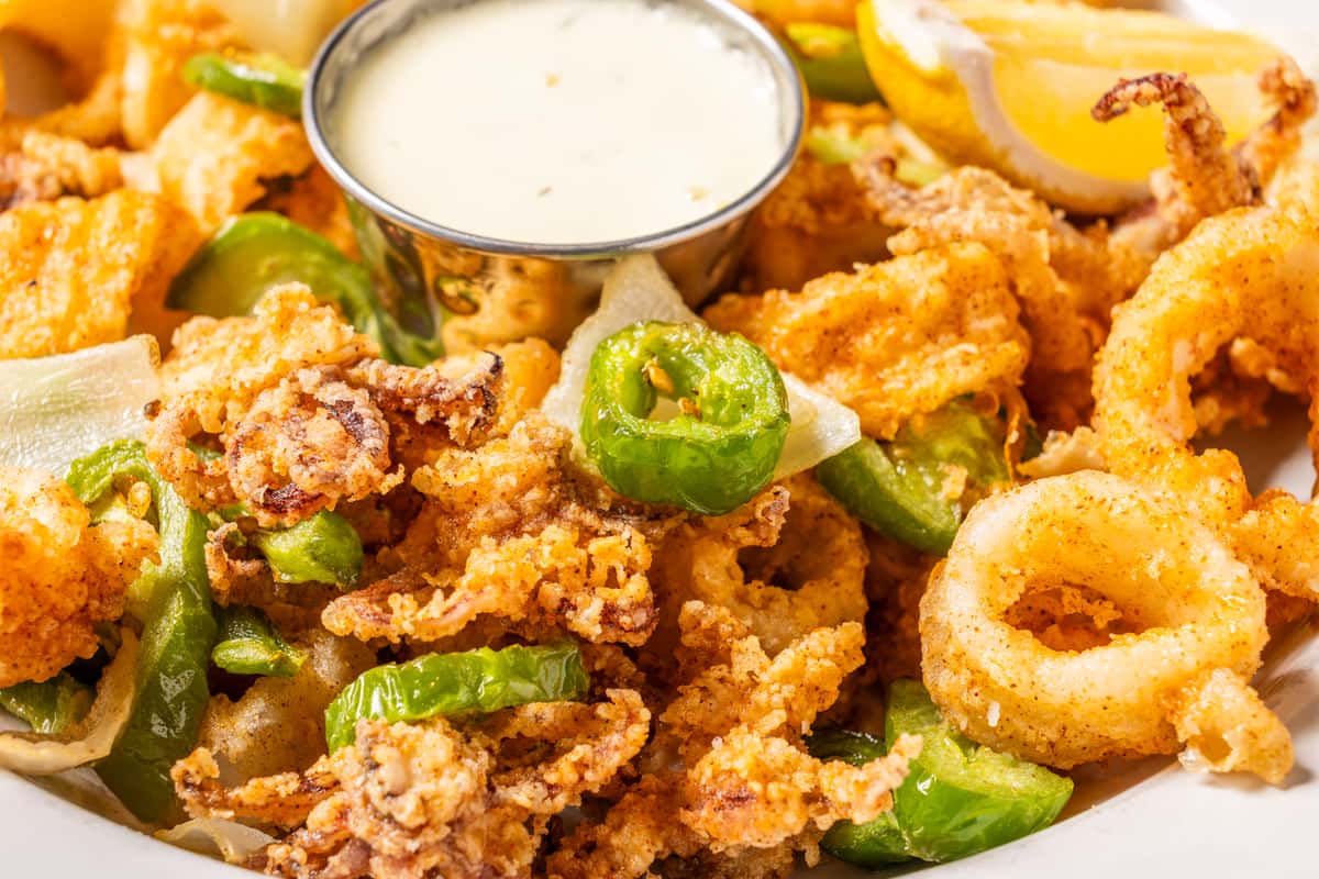 Crispy fried calamari with green peppers, onions, lemon wedges, and creamy dipping sauce.