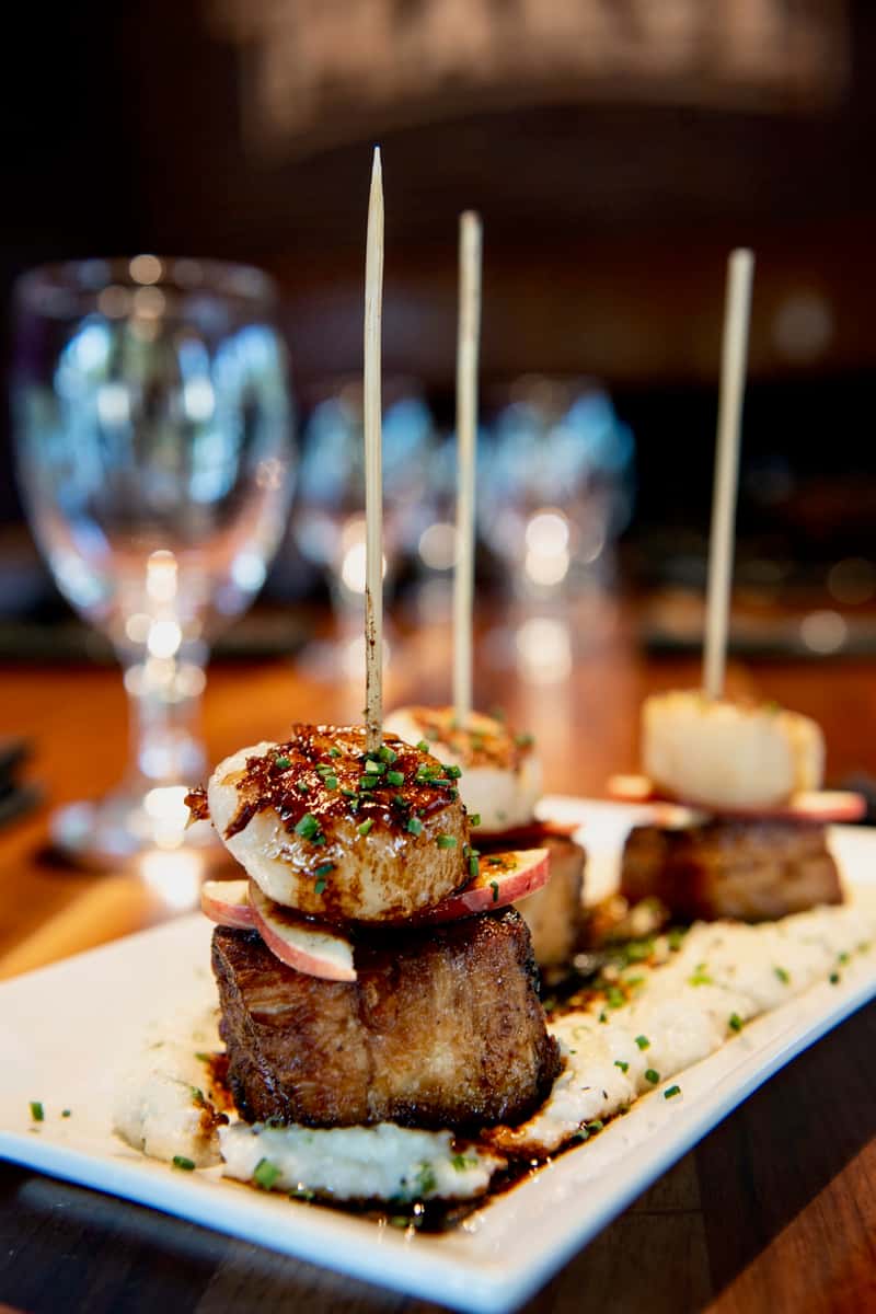 Gourmet appetizer skewers garnished with herbs and served at a fine dining restaurant