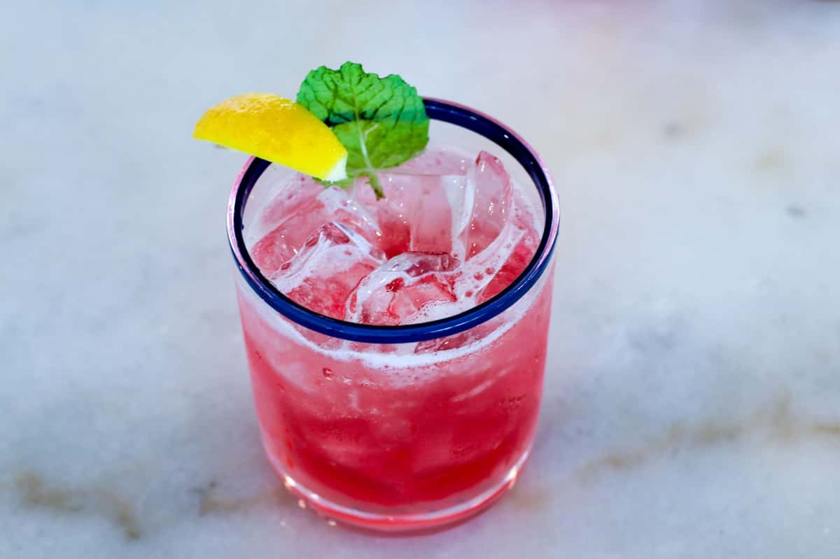 Pink cocktail with mint and lemon garnish