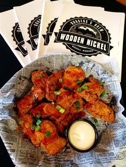 basket of boneless buffalo wings in a basket with a side of ranch, stack of Wooden Nickel napkins