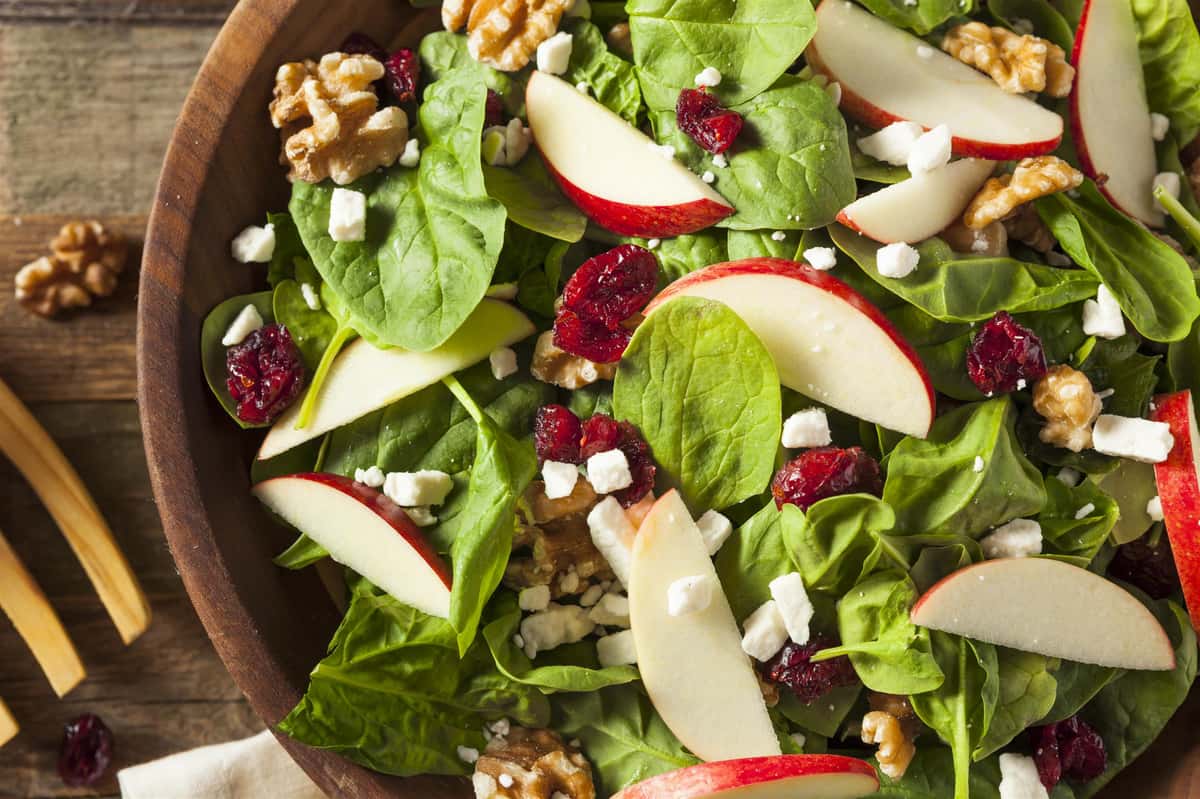 salad topped with feta cheese, cranberries and apples