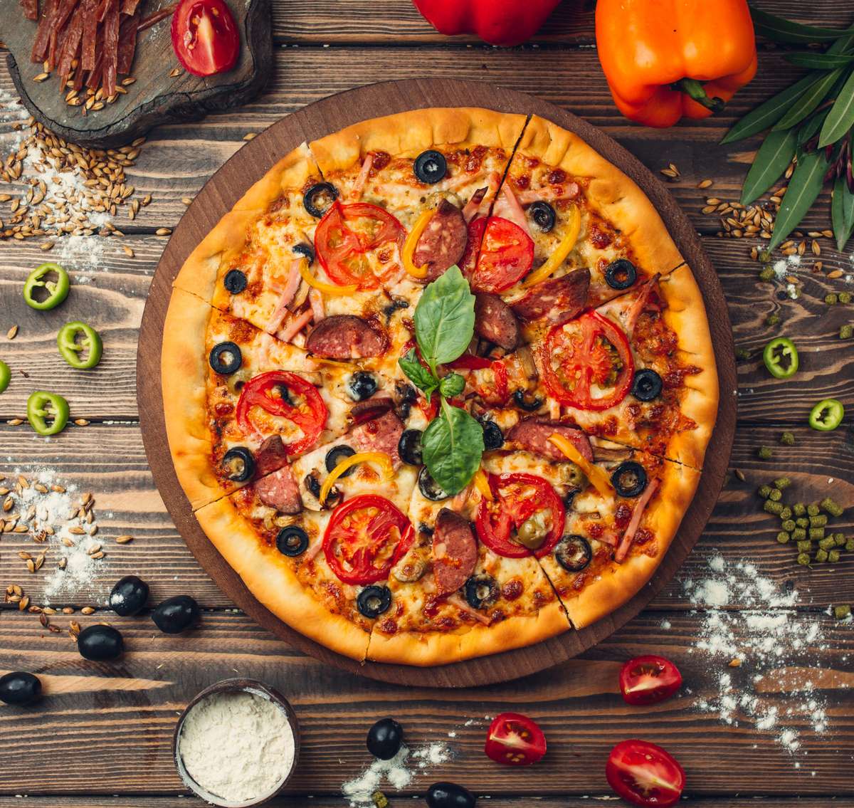 Cheezy Pizza's delicious-looking pizza sits on a wooden board, surrounded by pizza toppings.