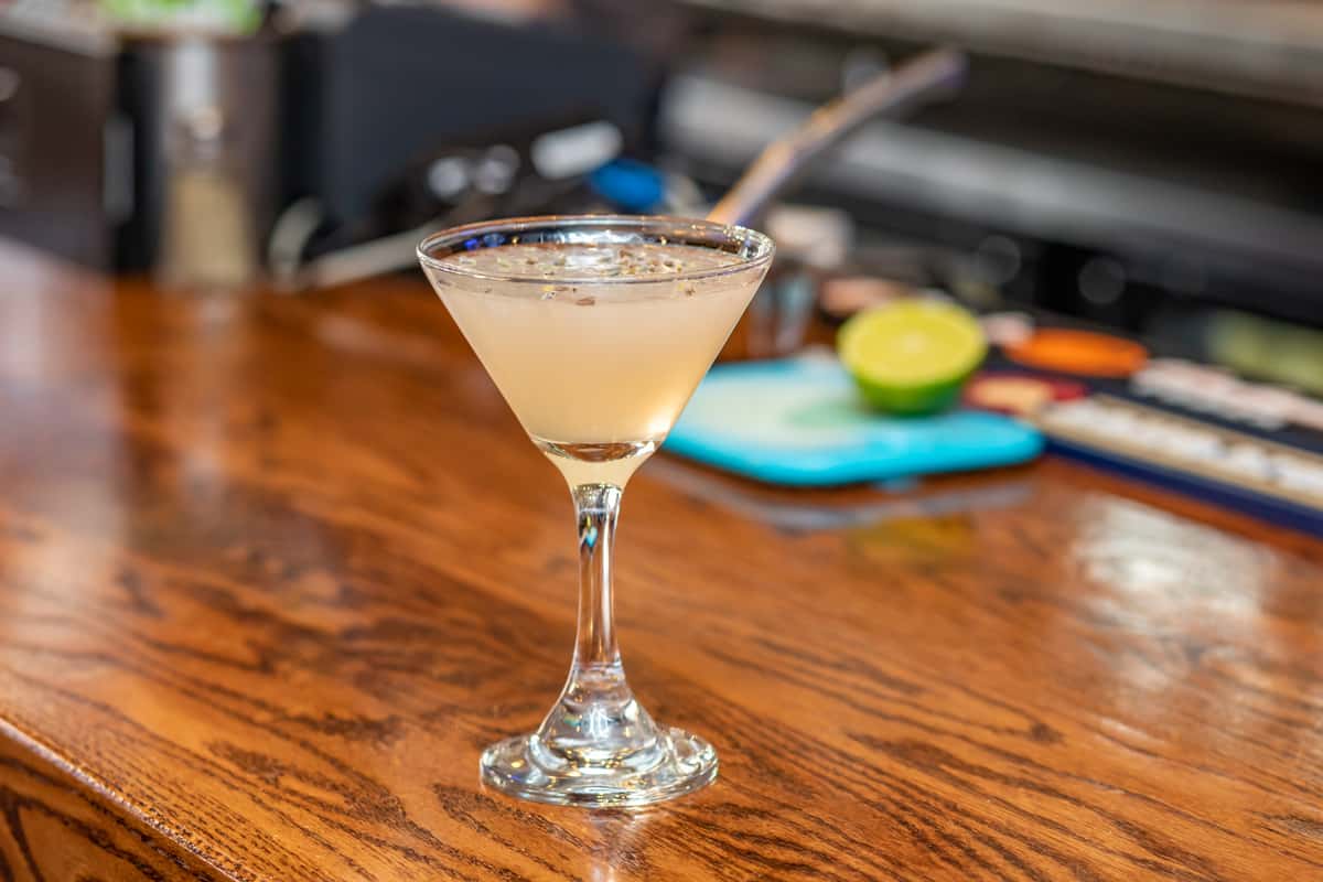 Classic lemon drop martini in a chilled stemmed glass on a polished wooden bar at Pourhouse Bar & Grill in Loveland.