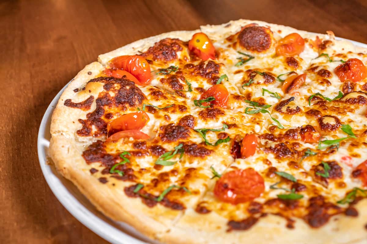 Wood-fired margherita-style pizza with mozzarella, roasted cherry tomatoes, and fresh basil at Pourhouse Bar & Grill in Loveland.