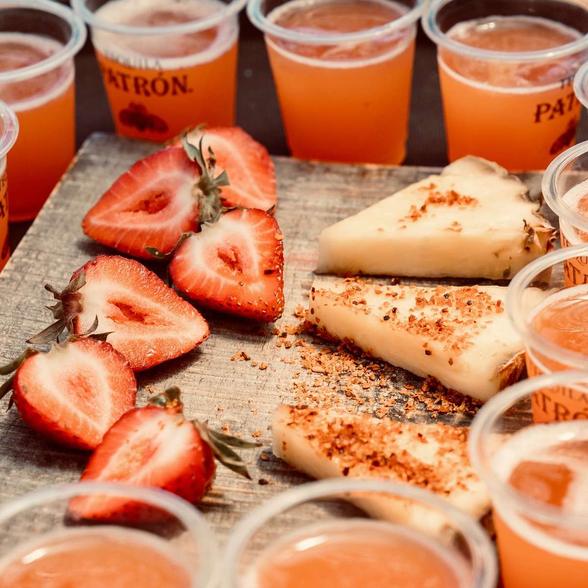 Tequila tasting flight with fresh strawberries and chili-rimmed cheesecake bites at a lively Mexican bar