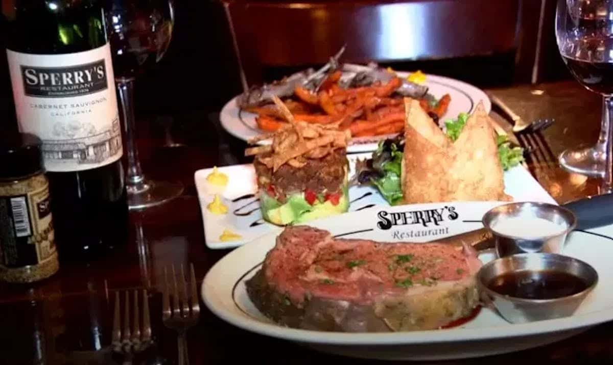Steak and seafood dinner with shrimp, baked potato, and wine at Sperry's Restaurant.
